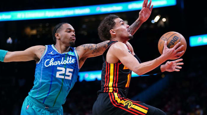 Atlanta Hawks guard Trae Young (11) drives to the basket past Charlotte Hornets forward P.J. Washington (25) during the first half of an NBA play-in basketball game Wednesday, April 13, 2022, in Atlanta.